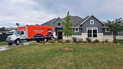 Mountain Movers truck outside a house for an Austin moving visit — movers Austin